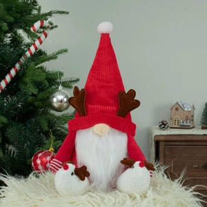 Détail d'un gnome de Noël en peluche avec bonnet rouge, bois de renne et barbe blanche