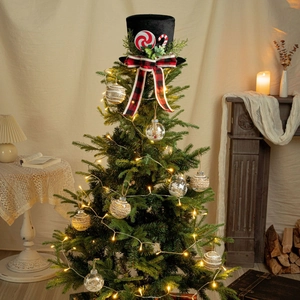 Close-up of black top hat Christmas tree topper with red ribbon and holiday ornaments