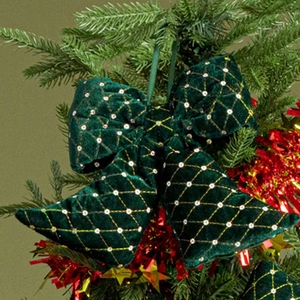 Detail of green velvet Christmas bow with gold diamond lattice and sequins on tree