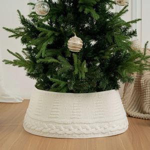 Makroansicht der weißen gestrickten Weihnachtsbaumdecke mit dickem Zopfmuster und Texturen