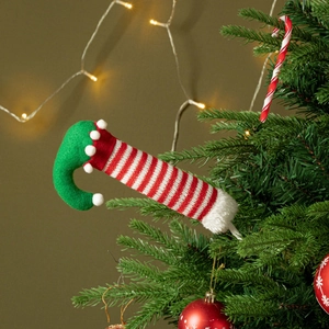 Detail of Christmas elf leg tree topper with red-white stripes and green plush fabric