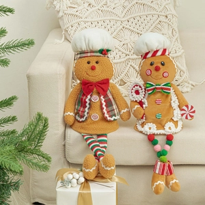 Close-up of plush gingerbread man dolls sitting on sofa with festive Christmas decor