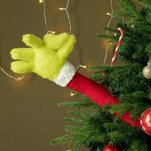 Close-up of a furry green Grinch arm ornament reaching out from a Christmas tree decoration
