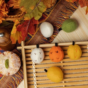 Handmade felt pinecone and pumpkin autumn harvest ornaments in warm seasonal colors