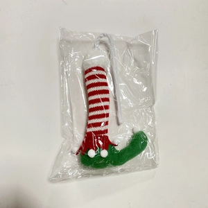 Detailed view of red and white striped Christmas elf leg hanging ornament in plastic packaging