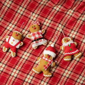 Set di quattro ciondoli di pan di zenzero in peluche con abiti natalizi su scacchi