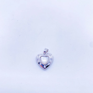 Macro shot of silver heart pendant with white mother of pearl inlay and zircon borders