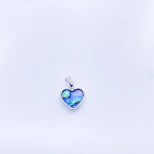 Macro detail of heart-shaped copper pendant with colorful abalone shell inlay