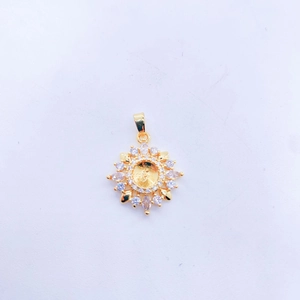 Golden sunflower pendant set with white crystals and frosted matte center on white paper