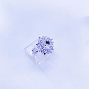 Detailed top view of a sunflower-shaped ring with cubic zirconia stones on an acrylic stand
