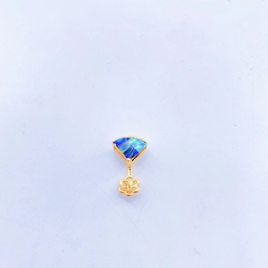 Close-up of fan-shaped pendant with blue shell inlay and gold hollow floral detail