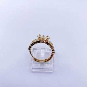 Detailed crown claw setting and hollow engraved ring base in golden finish