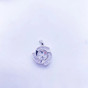 Dettaglio macro di un ciondolo a fiore argento con cristalli baguette e base centrale