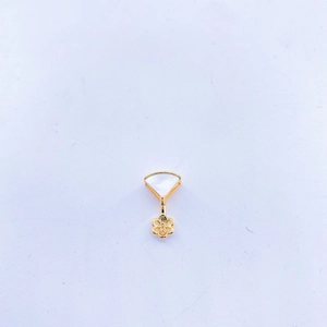 Detail of gold-plated pendant accessory featuring white shell and openwork flower design