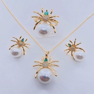 Conjunto de joyas de araña en metal chapado en oro con perlas y gemas verdes en blanco