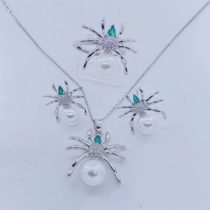 Conjunto de joyas de araña plateada con perlas blancas y ojos de piedras verdes lujo