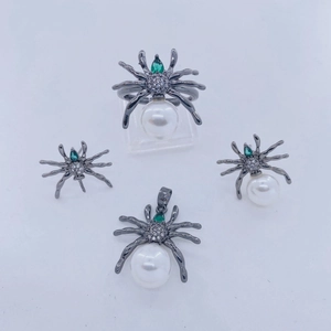 Conjunto de joyas de araña con metal negro, perlas blancas y piedras verdes brillantes