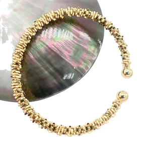 Gold open C-shape cuff bracelet with textured multi-layered metal discs and smooth ball ends