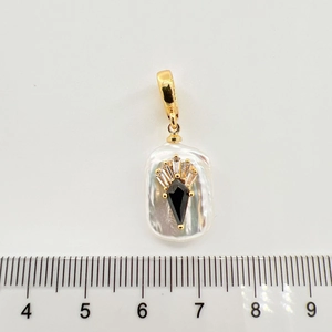 Detail eines Barockperlenanhängers mit schwarzem Edelstein und vergoldeter Öse mit Lineal