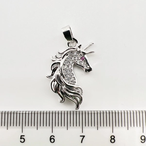 Vue détaillée du pendentif licorne serti de zircons blancs avec un œil rouge