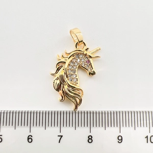 Vue détaillée du pendentif licorne doré avec zircons montrant la mesure de 2,5 cm
