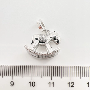 Pendentif cheval à bascule argenté avec zircons et règle indiquant 2cm de largeur