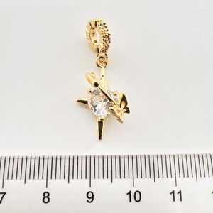 Macro détaillée d'un pendentif étoile dorée avec zircon cœur et échelle de mesure