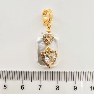Makroaufnahme von Barockperlenanhänger mit Herz-Kristallcharms und goldenem Verschluss