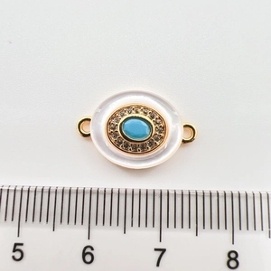 Macro detail of 18k gold plated turquoise pendant with shell inlay and scale reference