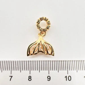 Détail du pendentif queue de poisson doré avec pierres et mesure sur règle