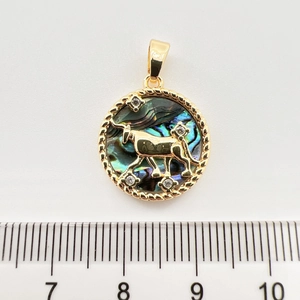 Makrodetail eines 2,5 cm Stier-Sternzeichen-Anhängers mit Goldstruktur und Abalone-Inlay