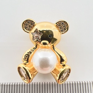 Dettaglio pendente a forma di orso con placcatura in oro e perla centrale