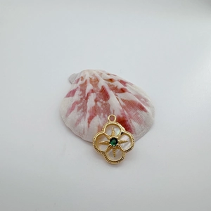 Detalle del colgante de trébol chapado en oro 18K con concha natural y circón verde