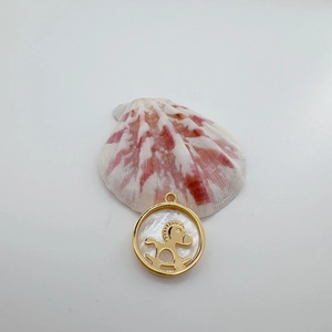 Detalle de colgante de nácar chapado en oro de 18K con motivo de caballito de madera oro