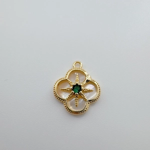 Detalle del colgante chapado en oro de 18K con gema verde e incrustación de nácar blanco