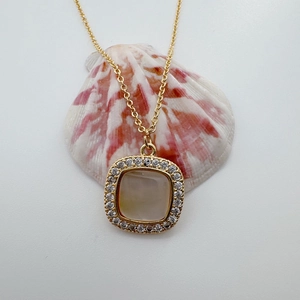 Detalle del colgante cuadrado chapado en oro 18K con piedra blanca y circonitas