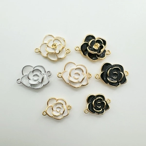 Détail des breloques camélia plaquées or 18K avec émail noir et blanc pour bijoux
