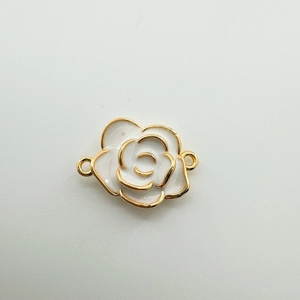 Détail macro d'une breloque camélia en plaqué or 18K avec émail blanc pour bijoux DIY