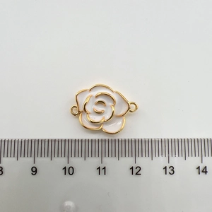 Détail d'une breloque camélia blanc plaqué or 18K avec règle mesurant sa longueur de 2,5 cm