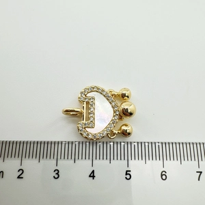 Detalle macro del colgante letra D bañado en oro 18K con nácar y circonitas incrustadas