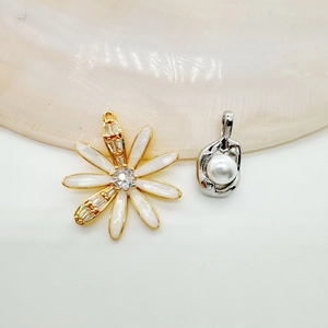 Exquisite 18K gold daisy charm and pearl pendant displayed on a natural shell background
