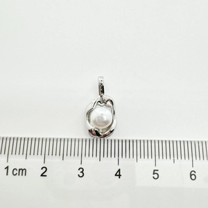 Macro detail of a 1.5cm flower-shaped pearl pendant showing precise size measurements