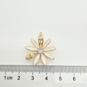 Detailed macro of 18K gold plated daisy pendant with white petals and tiny zircon accents