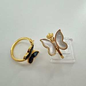 Detailed view of gold plated butterfly ring featuring white shell inlay and pearl setting