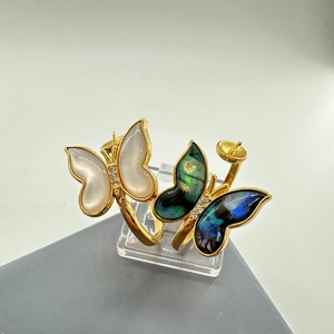 Macro view of butterfly jewelry components with gold plating and natural shell inlays