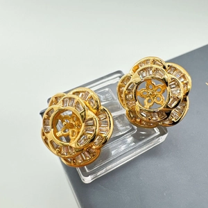 Macro detail of gold flower earrings with micro-pave cubic zirconia and camellia petals