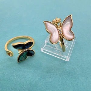 Detail of adjustable butterfly ring with dual-tone shell wings and small crystal accents