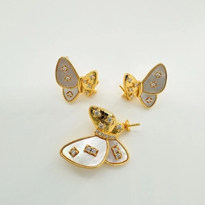 Close-up of gold-plated butterfly jewelry set with gray shell inlay and white zircons