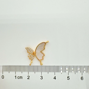 Macro-opname van 18K vergulde vlinder hanger met parelmoer en kristallen details