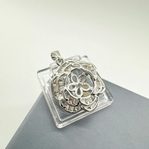 Macro shot of silver camellia flower pendant with cubic zirconia and shell petals
